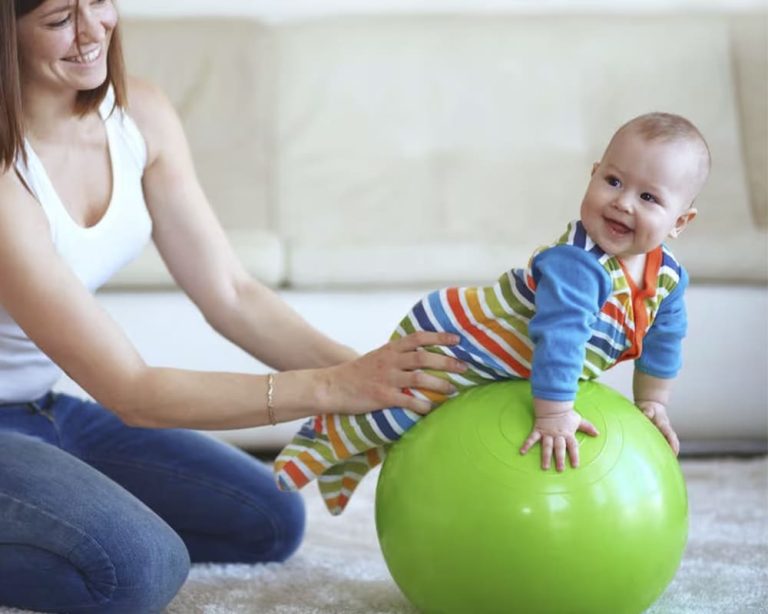 Bebé en actividad on balón terpuético para desarrollo del equilibrio.