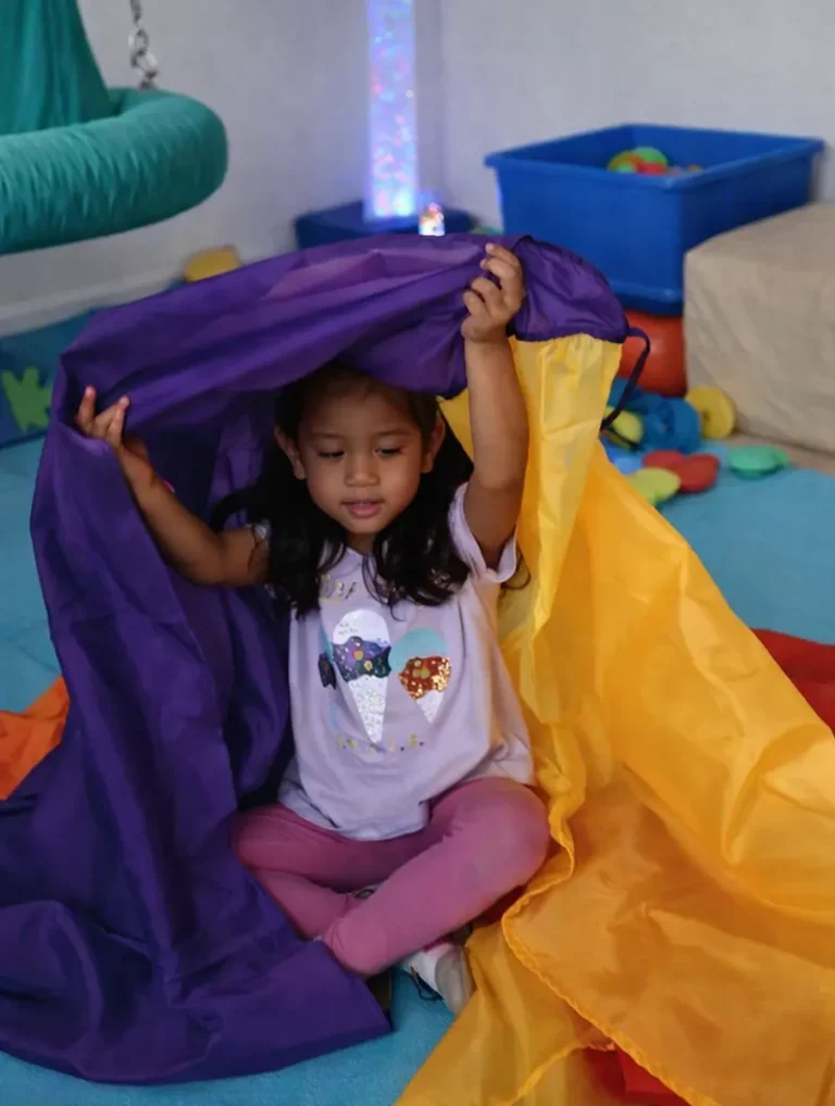Practi Kids, niña jugando con tela textil. Terapía Sensorial, estímulo de texturas.